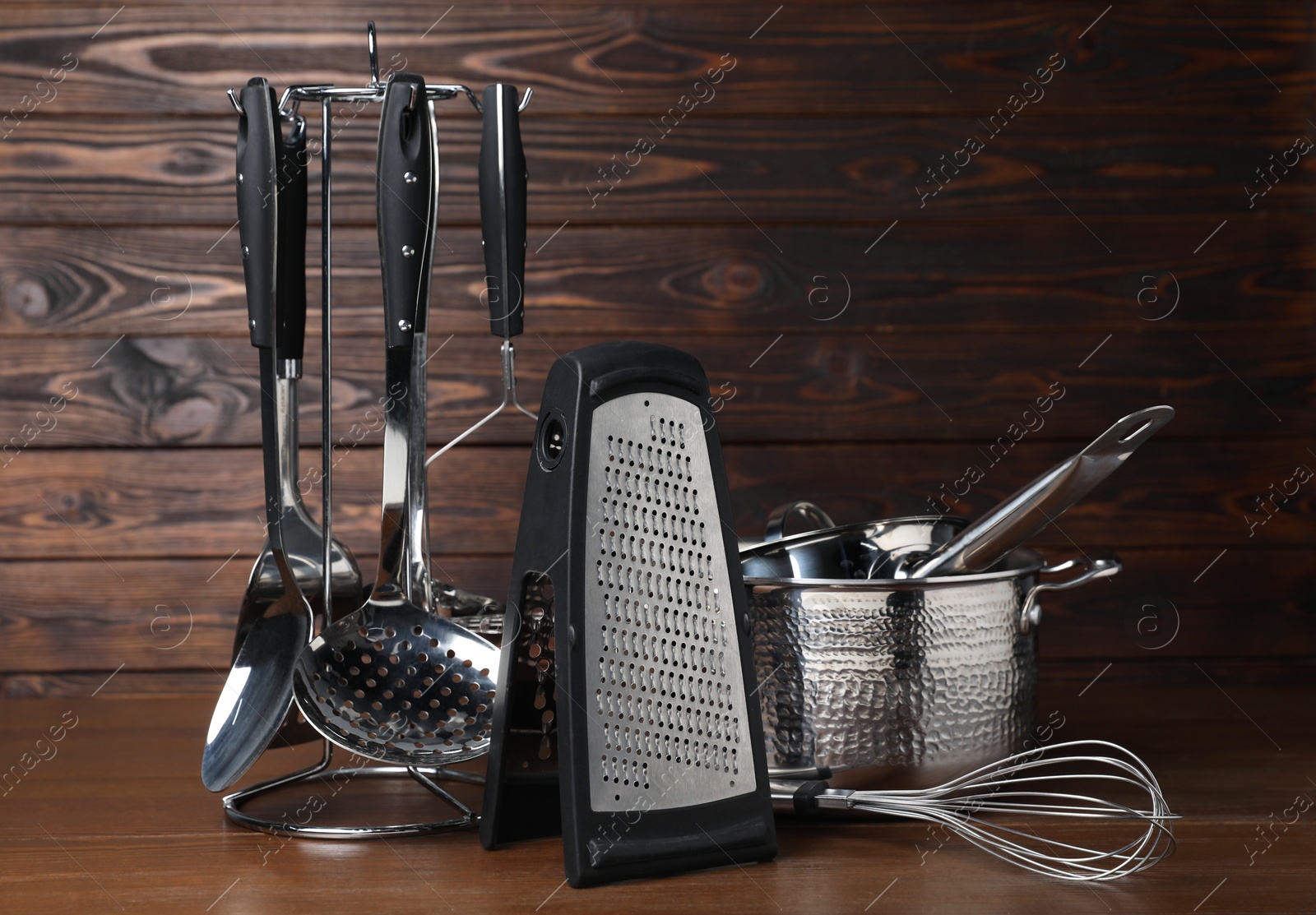 Photo of Dishware and cooking utensils on wooden table