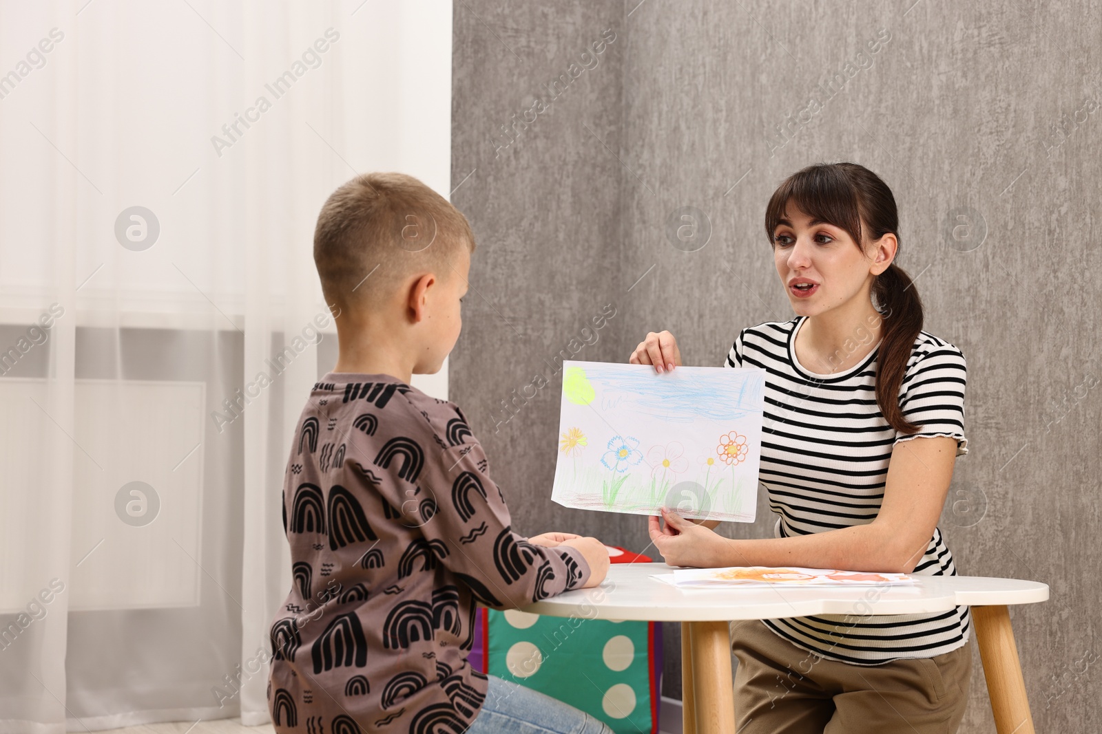 Photo of Autism therapy. Psychologist working with little boy at table in mental health center