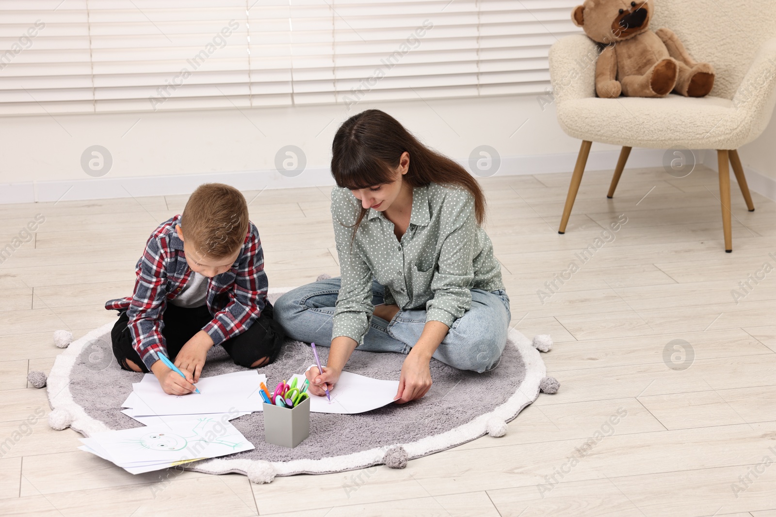 Photo of Autism therapy. Psychologist and little boy drawing pictures in mental health center