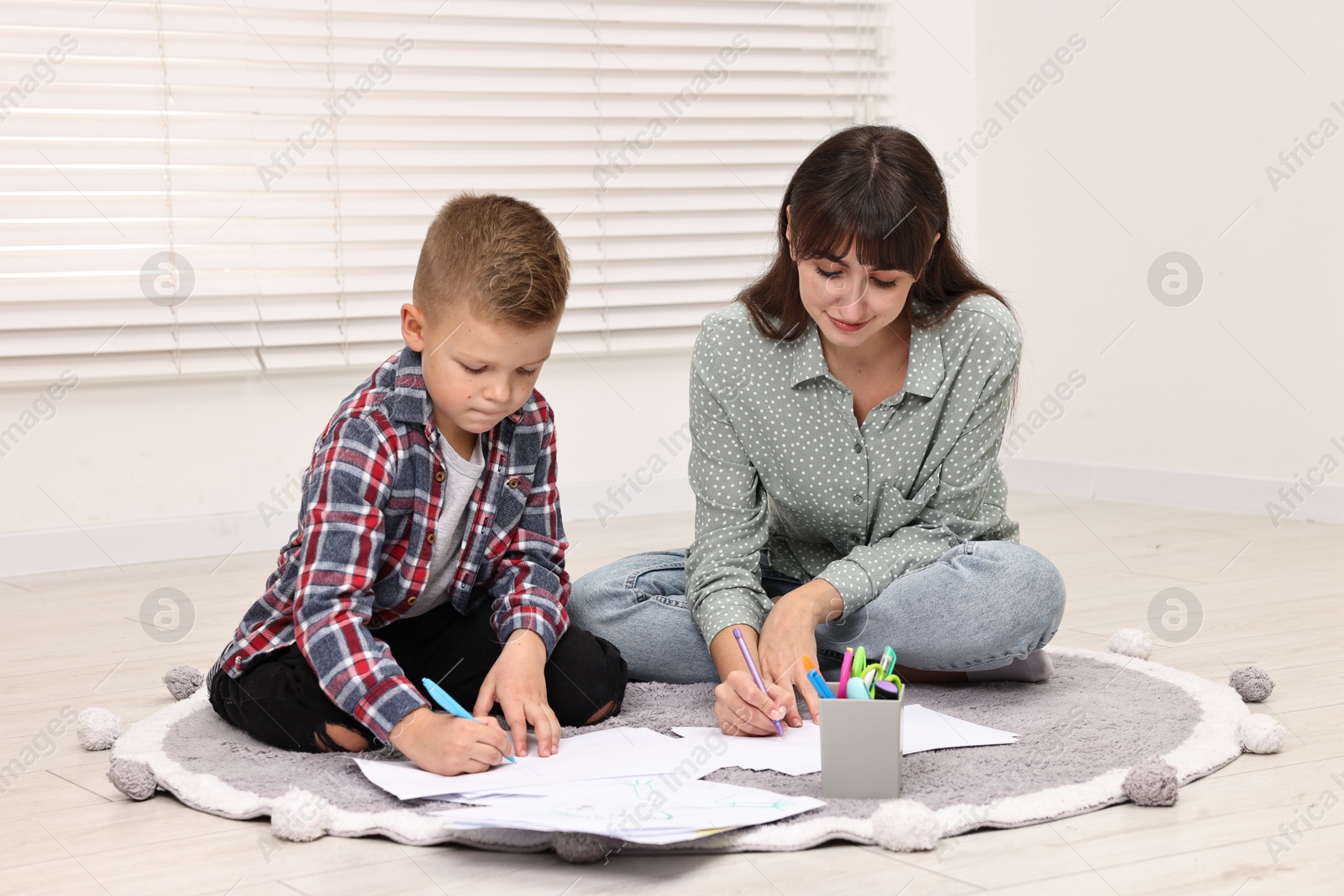 Photo of Autism therapy. Psychologist and little boy drawing pictures in mental health center