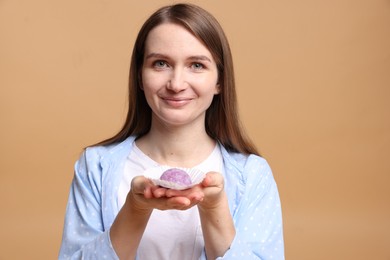 Photo of Woman with tasty mochi on light brown background