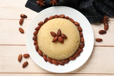 Photo of Delicious semolina halva with almonds on white wooden table, flat lay