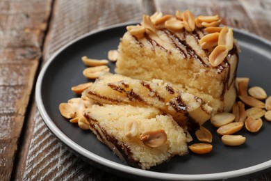 Photo of Delicious sweet semolina halva with peanuts on wooden table, closeup