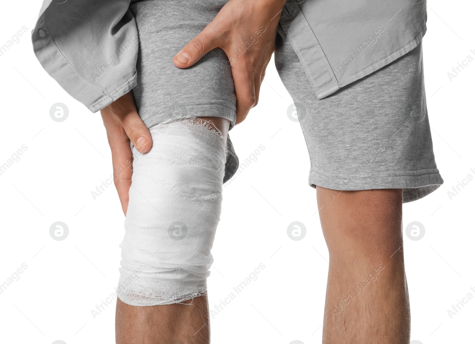 Photo of Man with medical bandage on his knee against white background, closeup