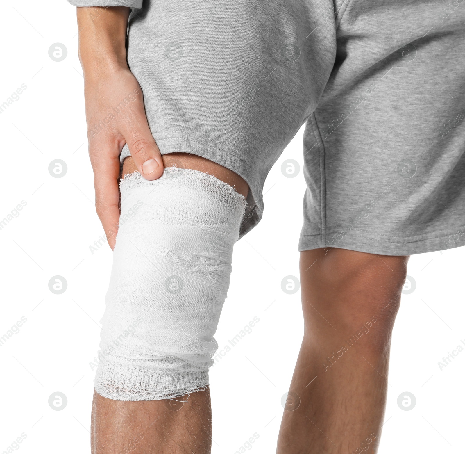 Photo of Man with medical bandage on his knee against white background, closeup