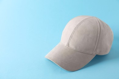 Photo of Stylish baseball cap on light blue background. Mockup for design