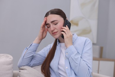 Photo of Stressed woman calling hotline for mental health help at home