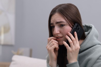 Photo of Stressed woman calling hotline for mental health help at home. Space for text