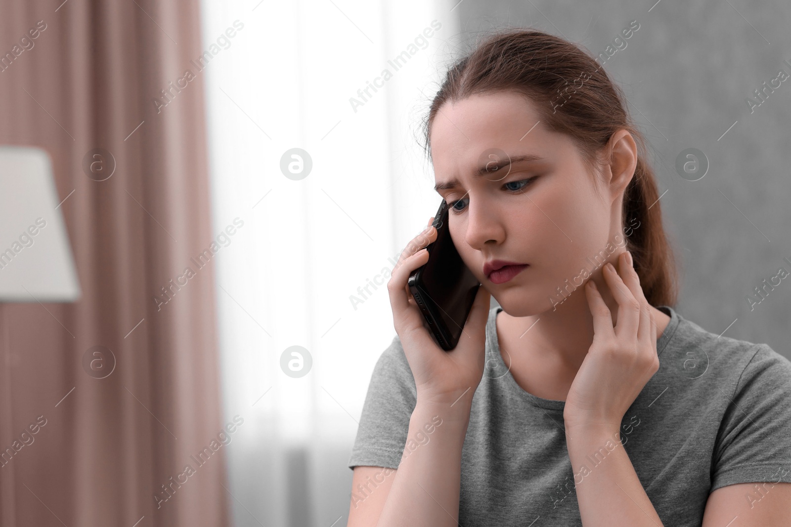 Photo of Stressed woman calling hotline for mental health help at home. Space for text