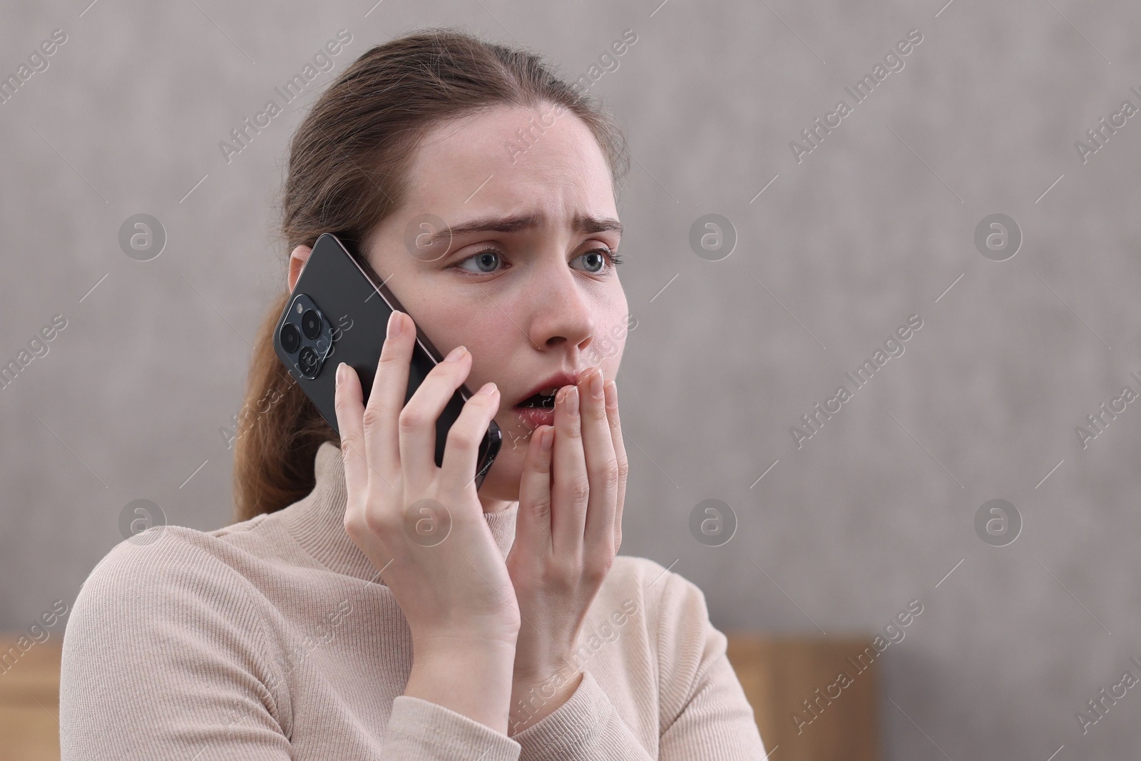 Photo of Stressed woman calling hotline for mental health help at home