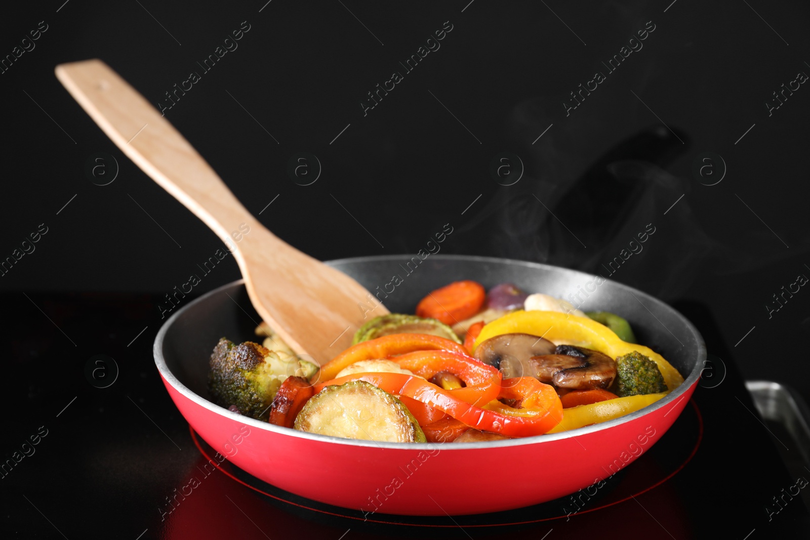 Photo of Frying pan with vegetables and mushrooms on stove, closeup