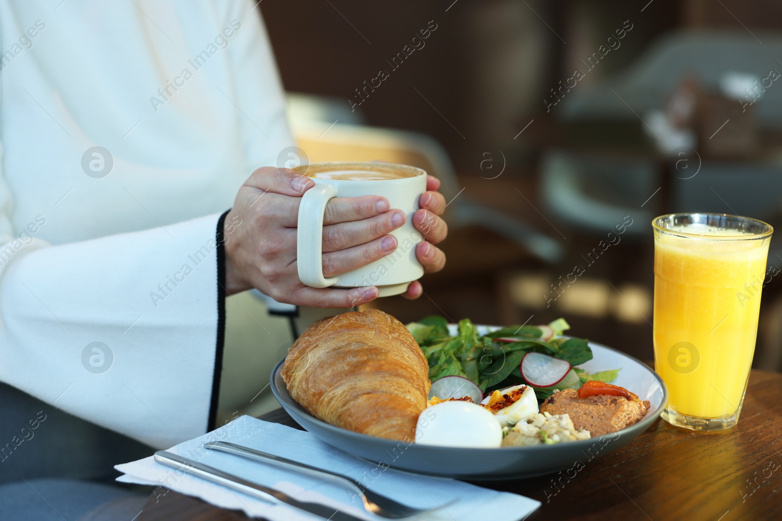 Photo of Woman having tasty breakfast in cafe, closeup