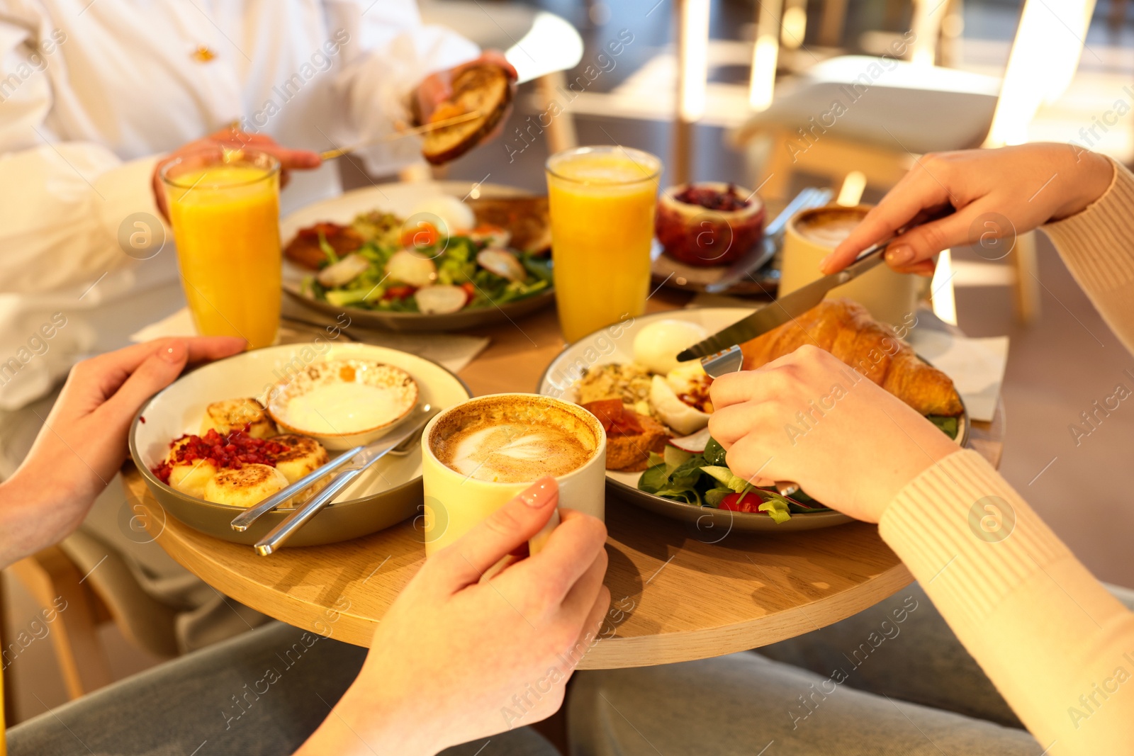 Photo of Women having tasty breakfast in cafe, closeup