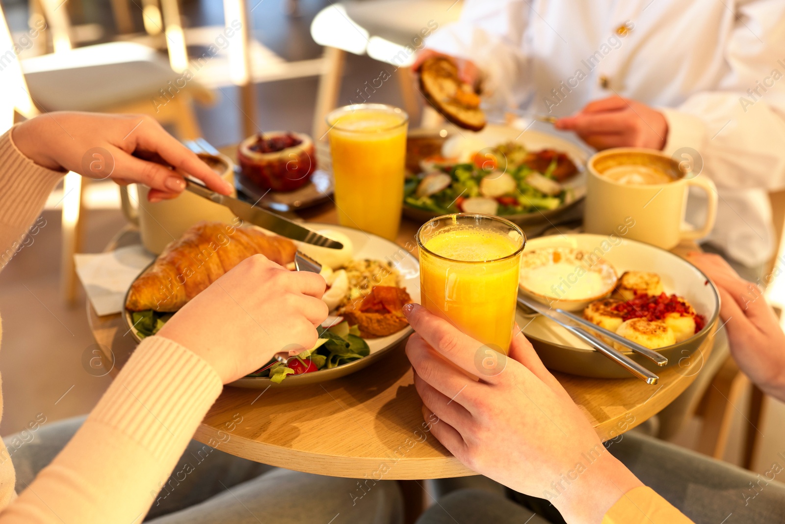 Photo of Women having tasty breakfast in cafe, closeup