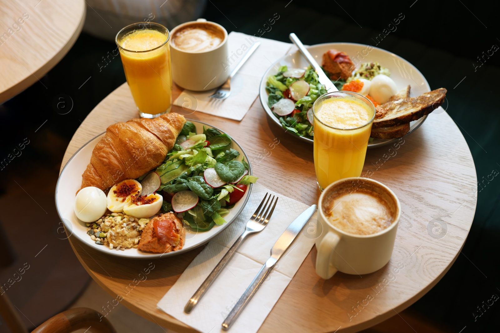 Photo of Tasty breakfast. Different meals and drinks served on wooden table in cafe