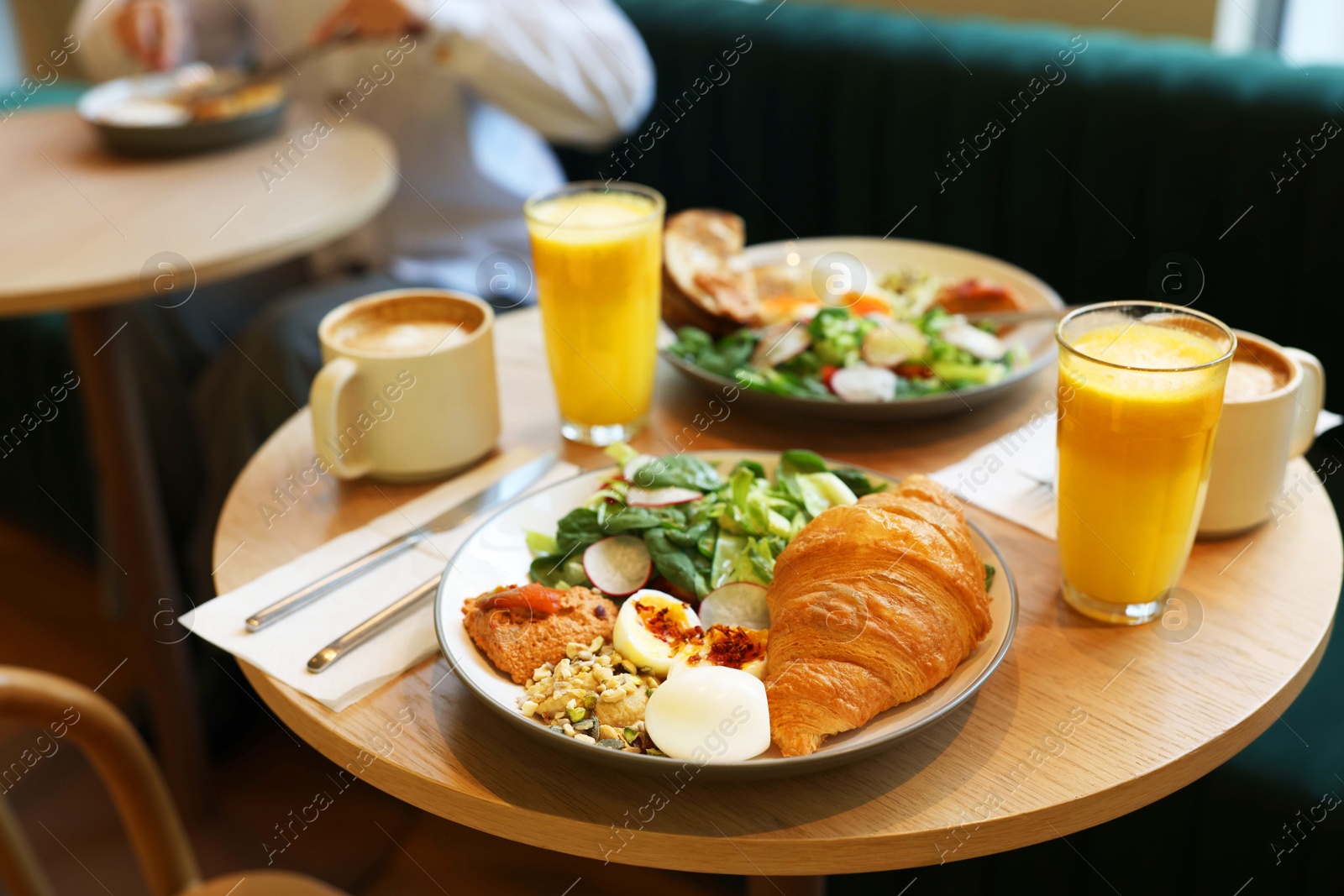 Photo of Woman having tasty breakfast in cafe, focus on different meals and coffee