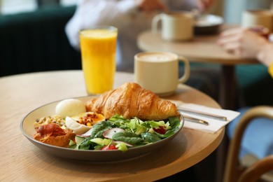 Photo of Women having tasty breakfast in cafe, selective focus