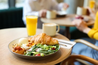 Photo of Women having tasty breakfast in cafe, selective focus