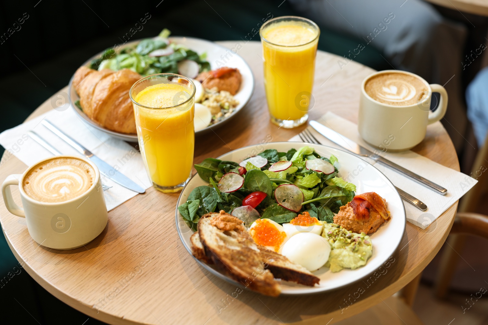 Photo of Tasty breakfast. Different meals and drinks served on wooden table in cafe, closeup