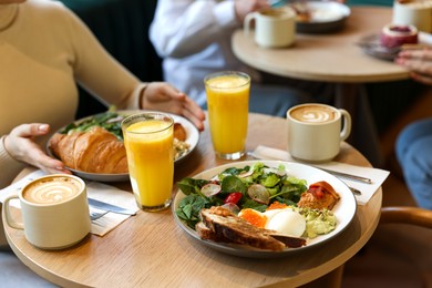 Photo of Woman having tasty breakfast in cafe, closeup