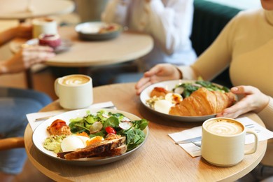 Photo of Woman having tasty breakfast in cafe, closeup