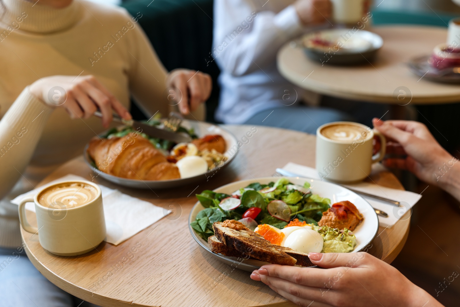 Photo of Women having tasty breakfast in cafe, closeup