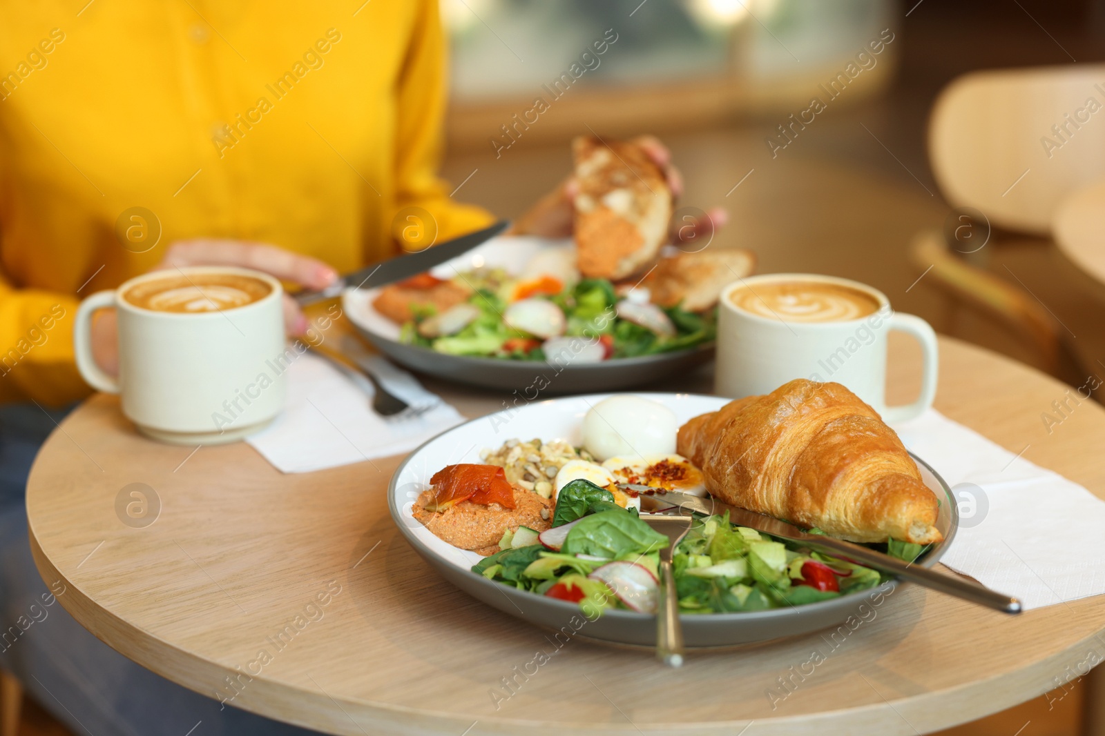 Photo of Woman having tasty breakfast in cafe, closeup