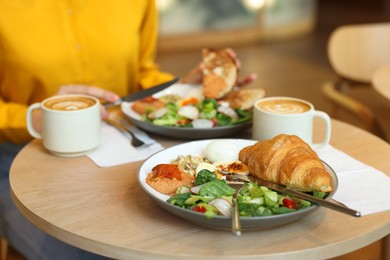 Photo of Woman having tasty breakfast in cafe, closeup