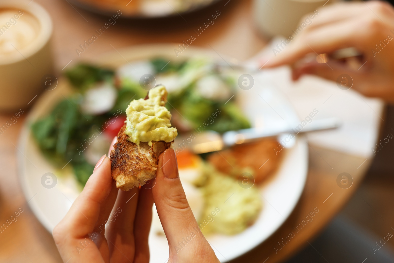 Photo of Woman having tasty breakfast in cafe, closeup