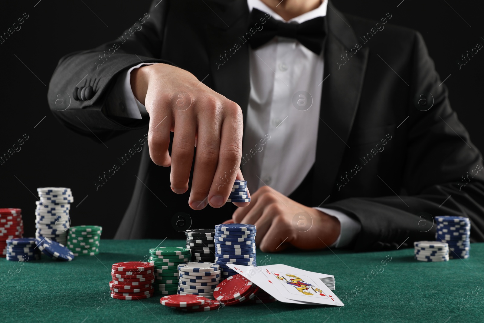 Photo of Man with cards and casino chips playing poker at gambling table, closeup