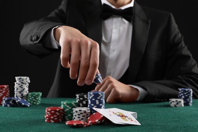 Photo of Man with cards and casino chips playing poker at gambling table, closeup