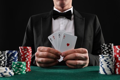 Photo of Man with cards and casino chips playing poker at gambling table, closeup