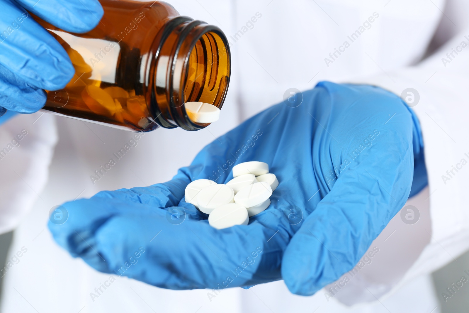 Photo of Doctor with bottle of antibiotic pills, closeup