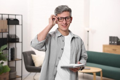 Portrait of professional psychologist with notebook in office