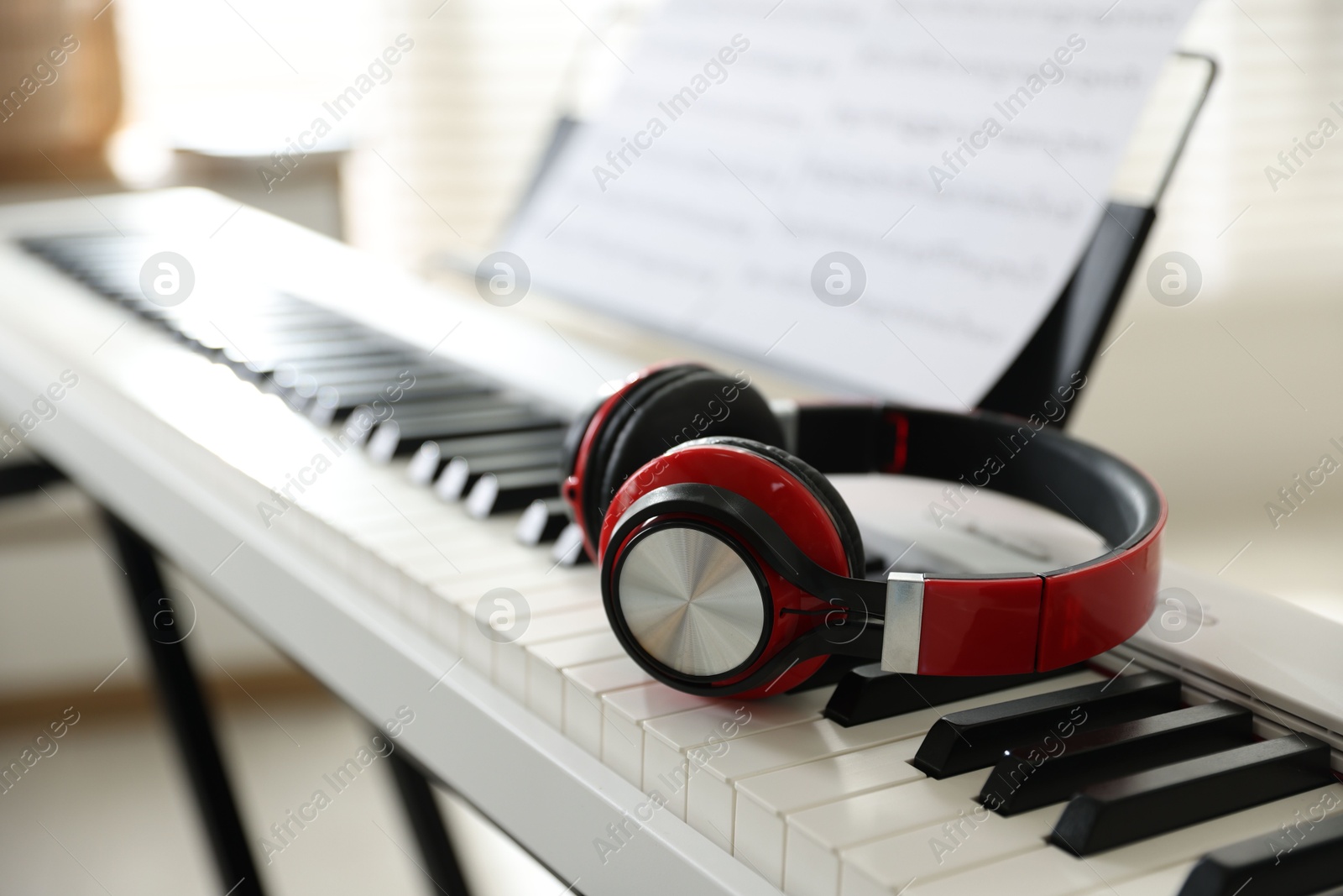 Photo of Synthesizer with music sheets and headphones indoors, closeup