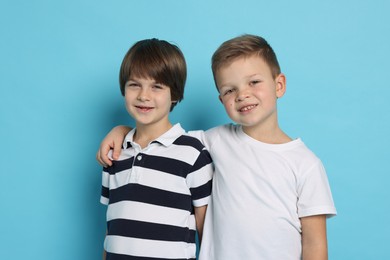 Photo of Portrait of cute brothers on light blue background