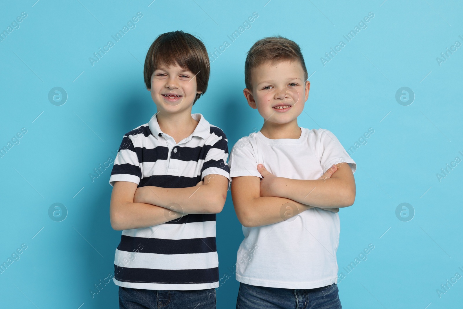 Photo of Portrait of cute brothers on light blue background