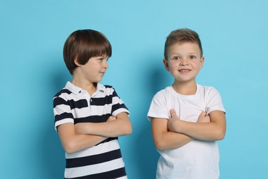 Photo of Portrait of cute brothers on light blue background