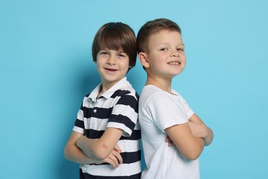 Photo of Portrait of cute brothers on light blue background