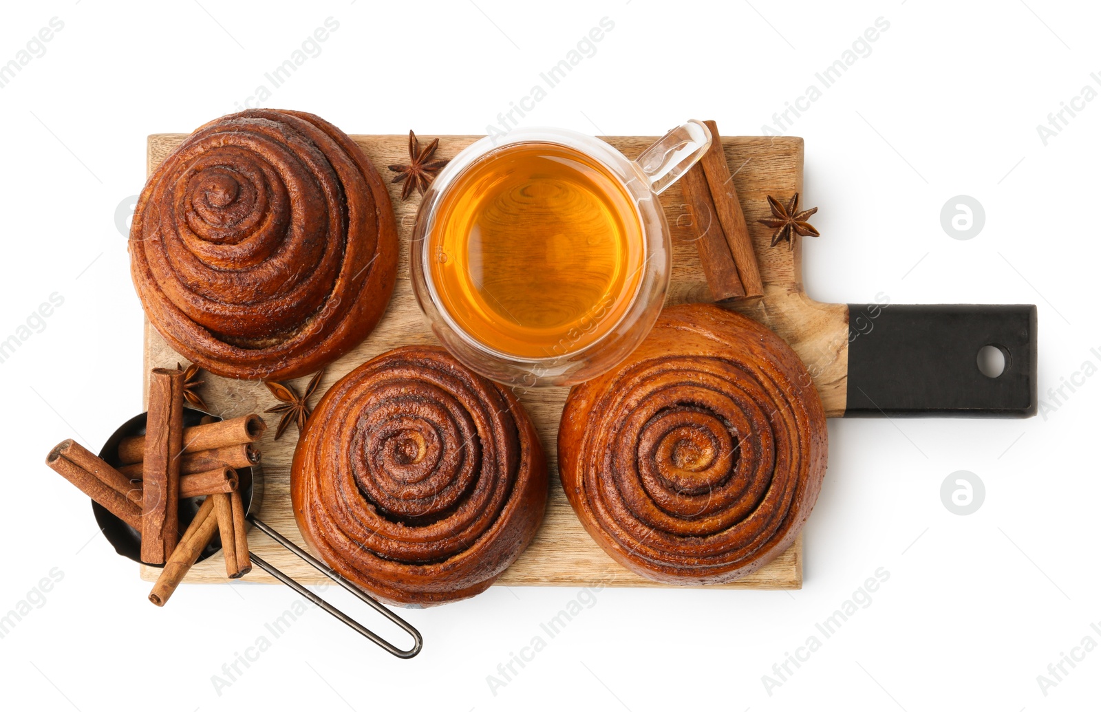 Photo of Delicious cinnamon roll buns with tea and spices isolated on white, top view