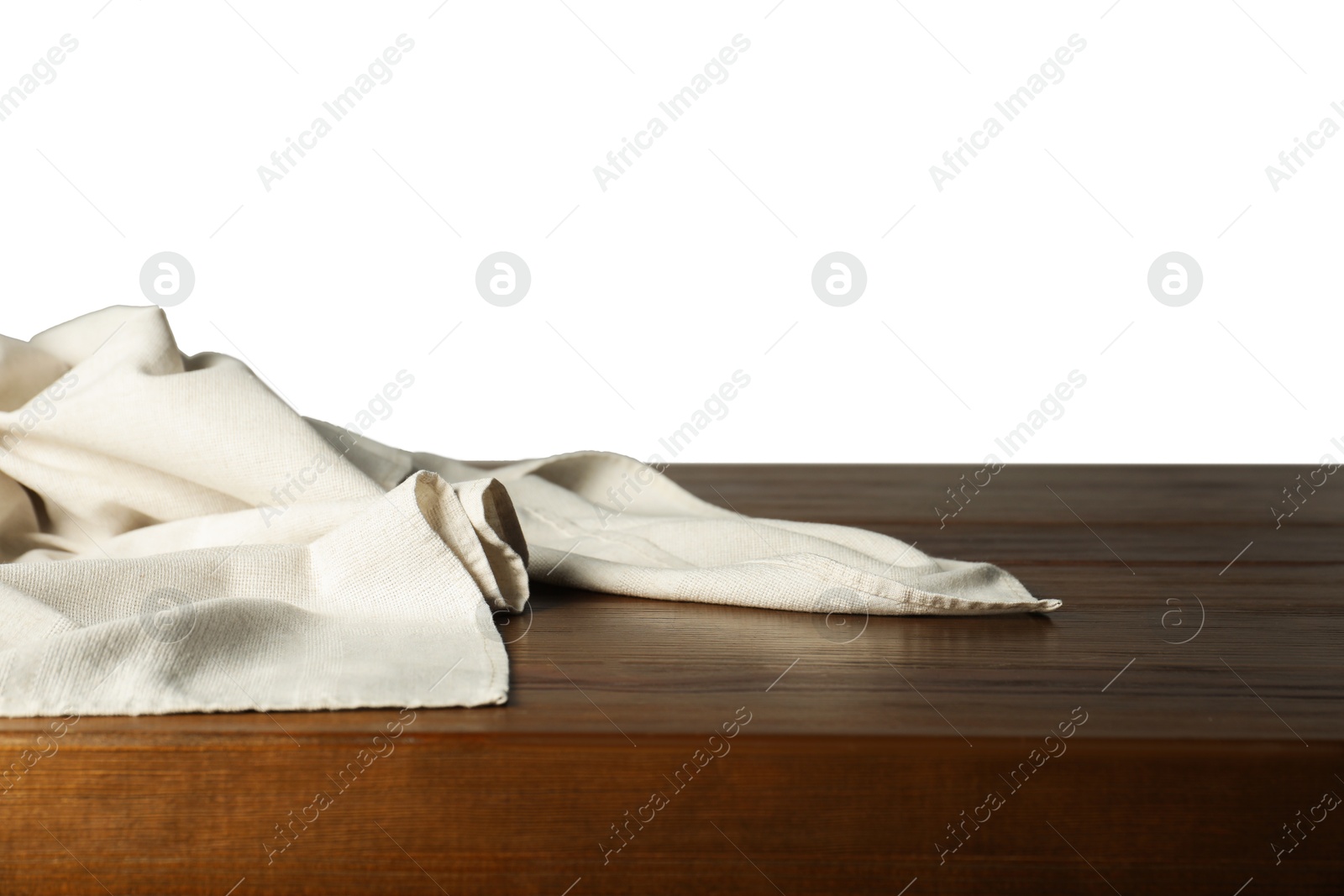 Photo of Light tablecloth on wooden table against white background, closeup