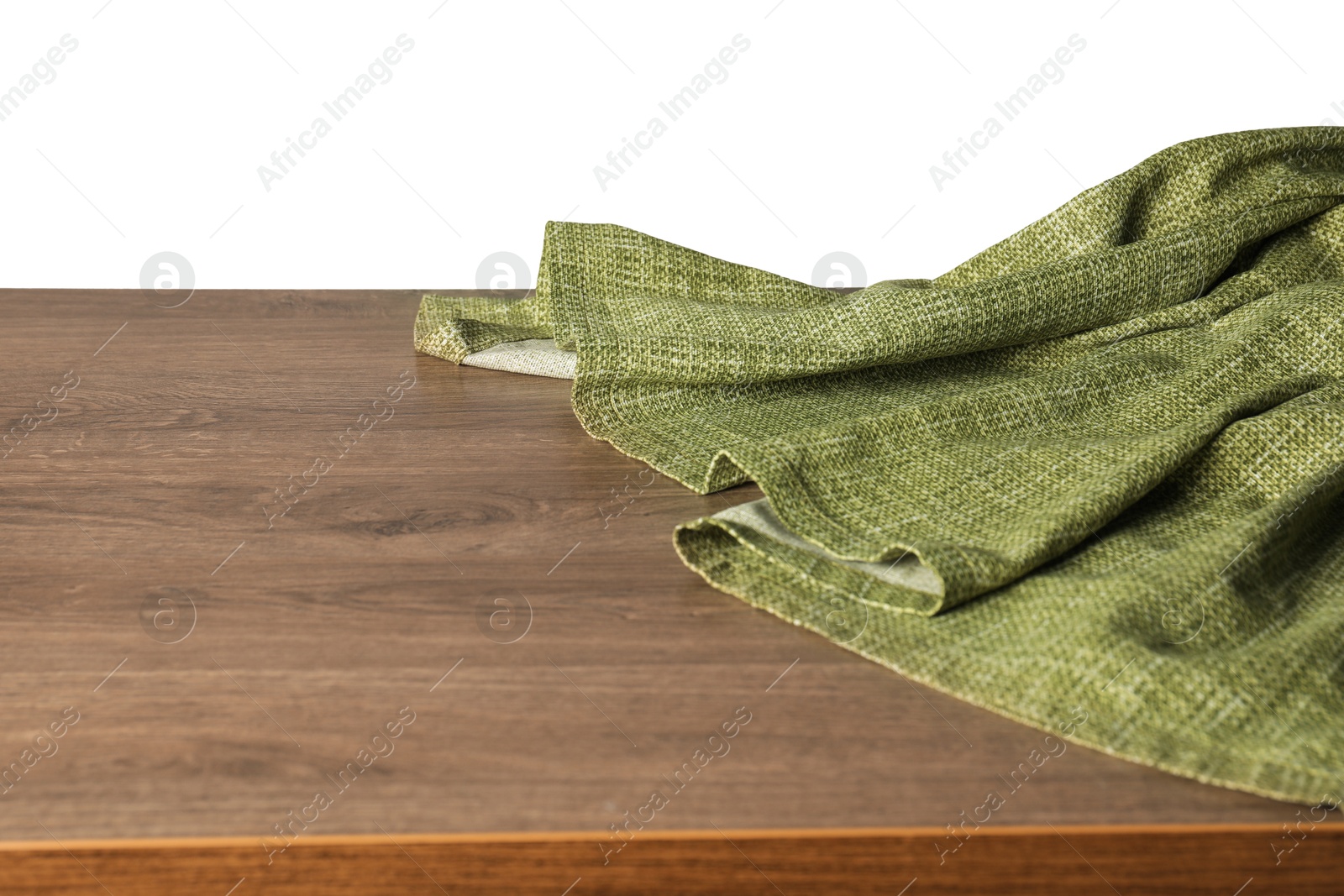 Photo of Green tablecloth on wooden table against white background, closeup