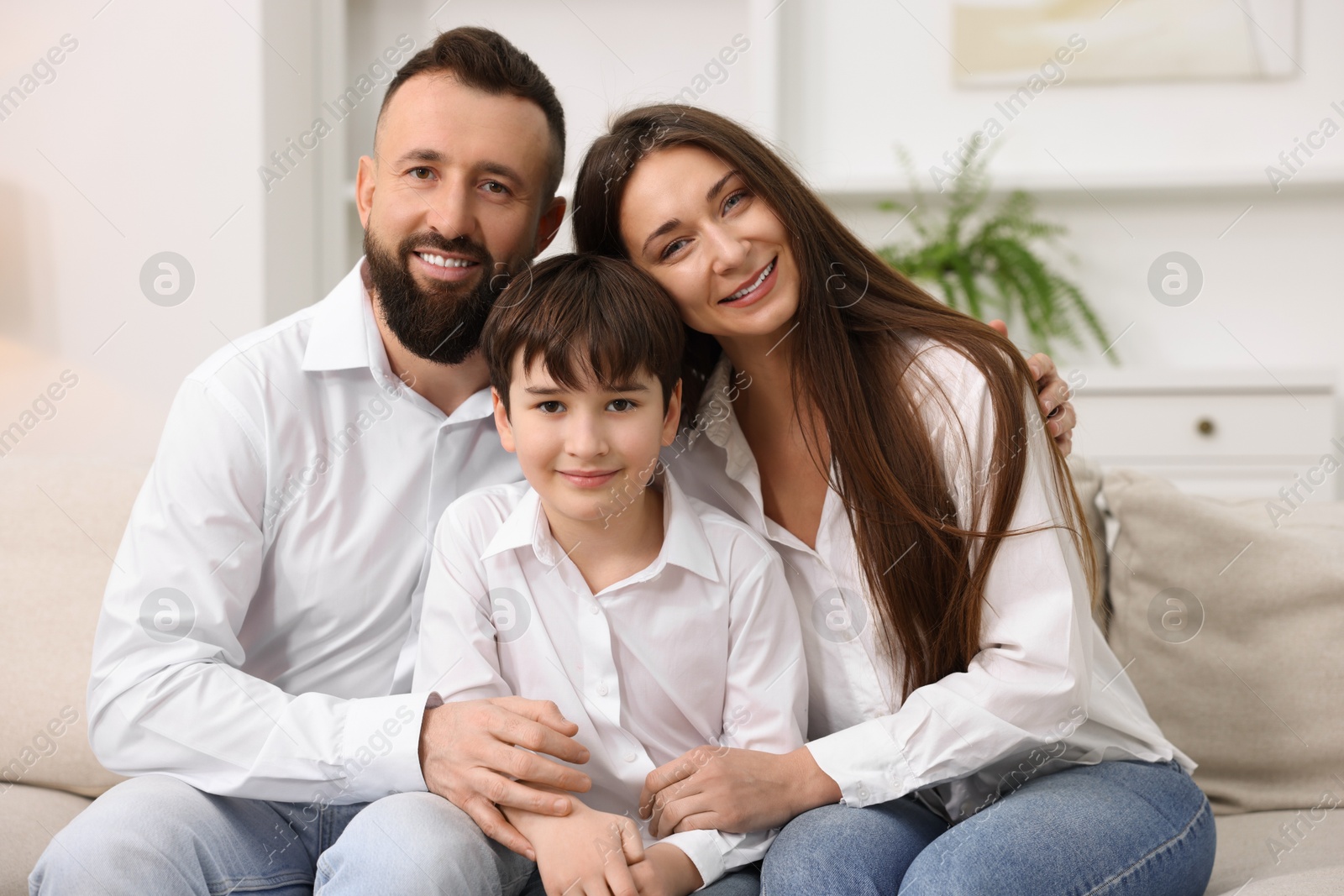 Photo of Happy parents and their son on sofa at home