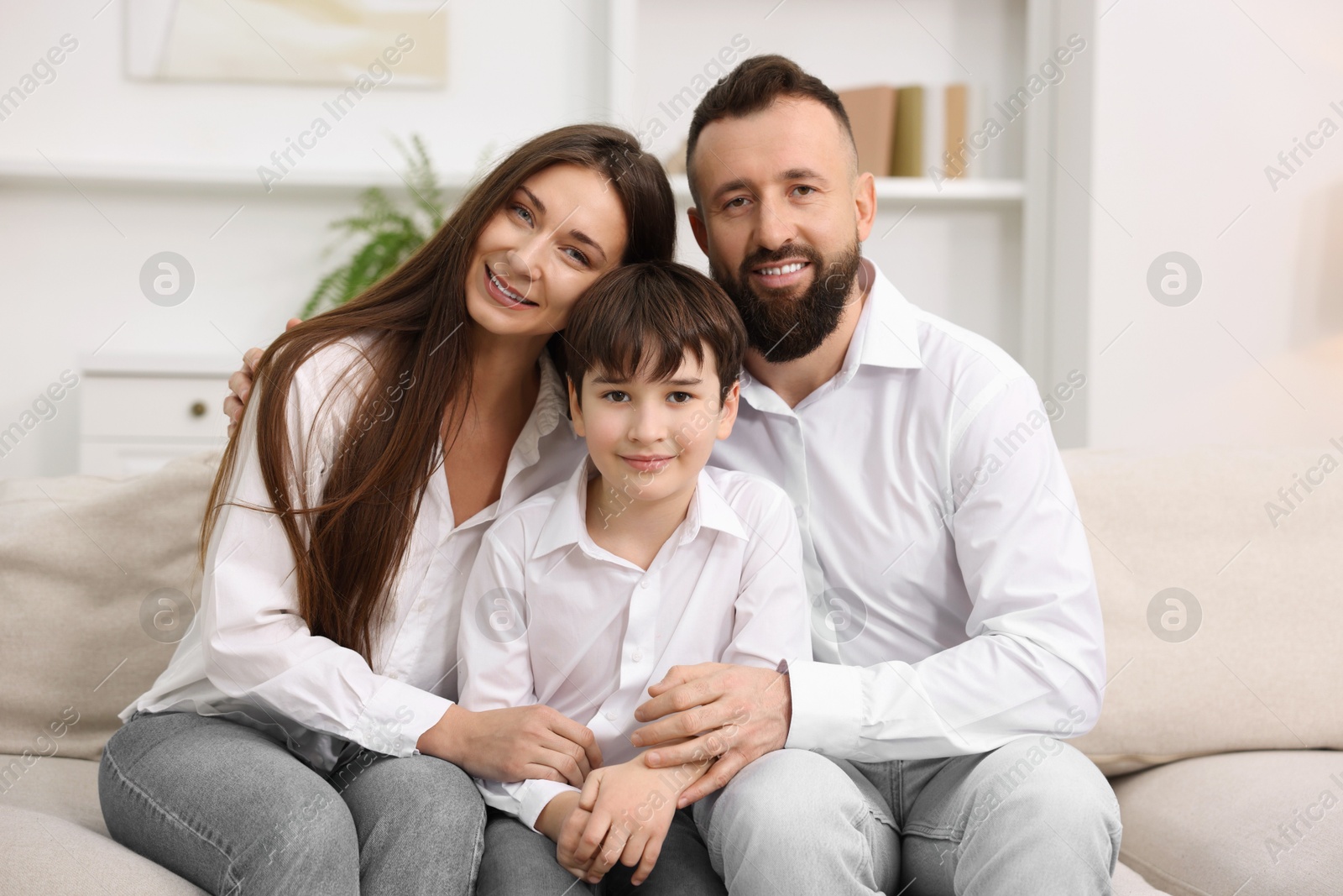 Photo of Happy parents and their son on sofa at home