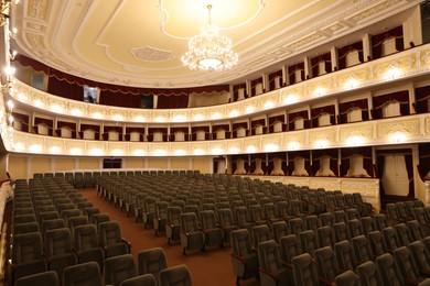 Photo of Rows of gray comfortable seats in theatre