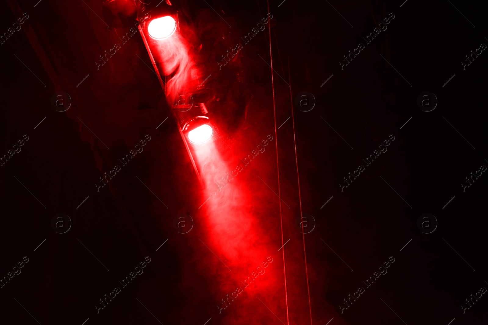 Photo of Professional spotlights and smoke on stage in theatre