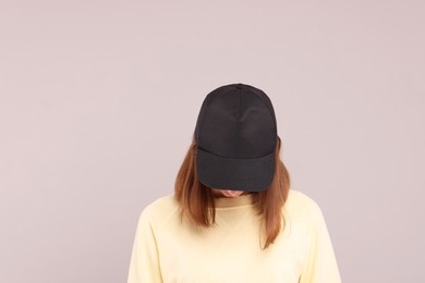 Photo of Woman in stylish baseball cap on grey background. Mockup for design