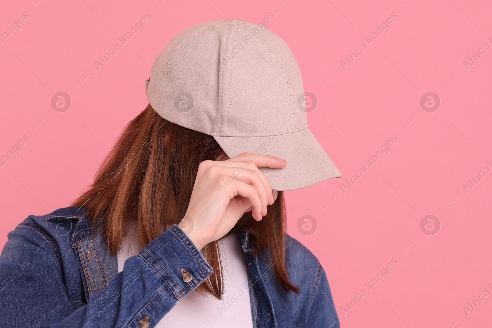 Photo of Woman in stylish baseball cap on pink background. Mockup for design