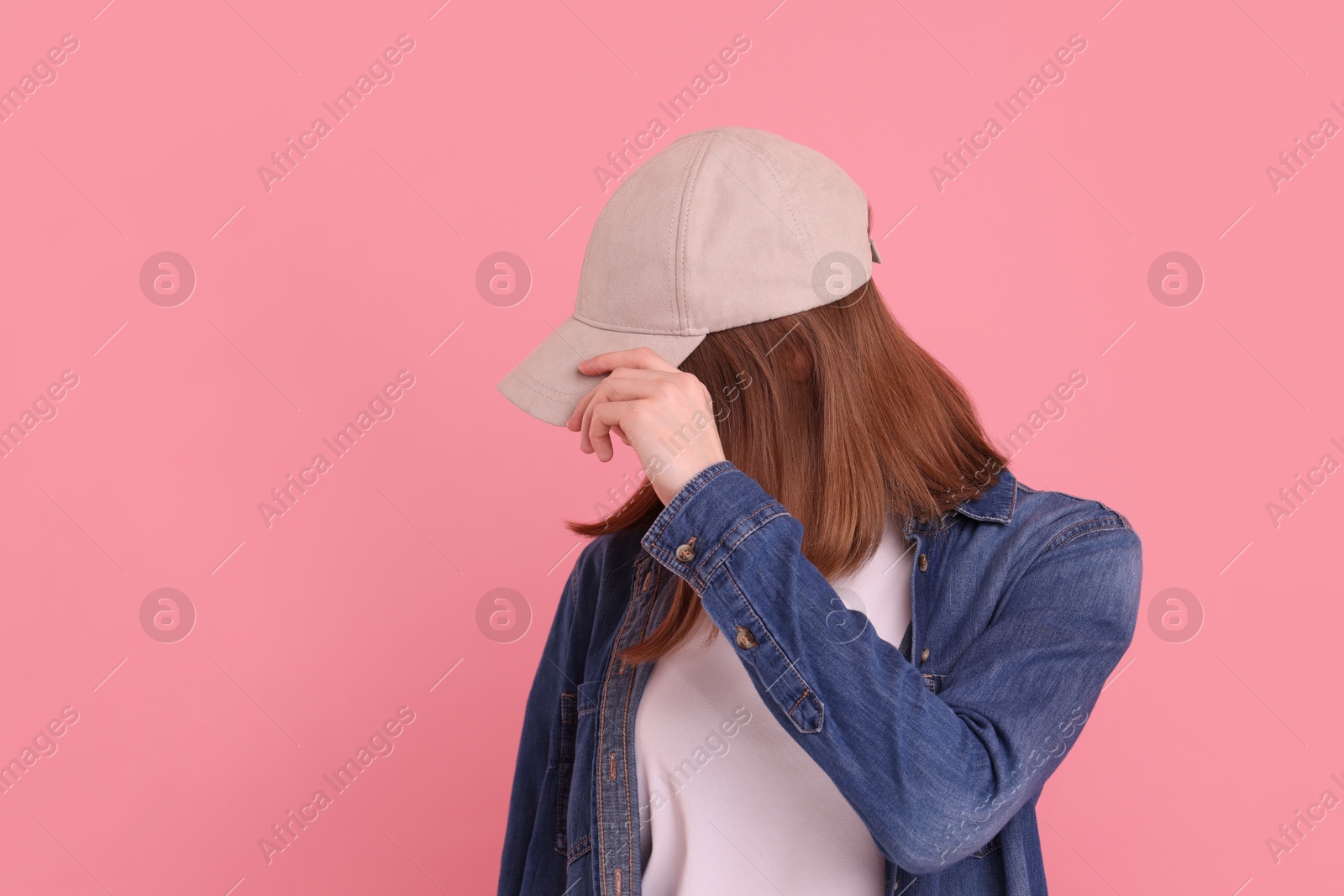 Photo of Woman in stylish baseball cap on pink background. Mockup for design