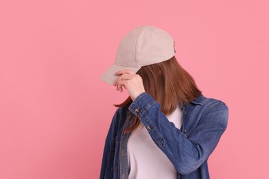 Photo of Woman in stylish baseball cap on pink background. Mockup for design